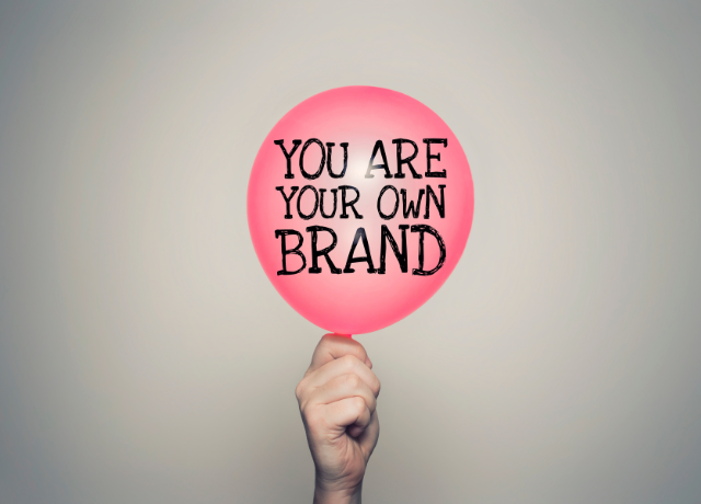 pink balloon held by a hand with words on it relating to personal branding