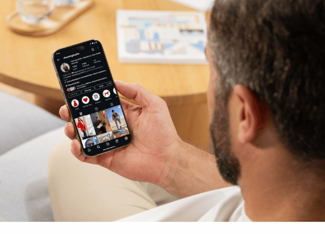 man holding phone showing screen of personal social media account relating to personal branding