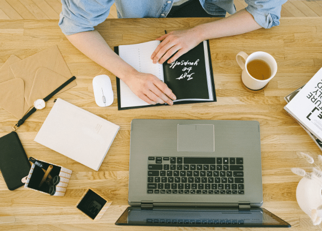 top view of desk with laptop and office items relating to doing your own diy marketing retreat for small business
