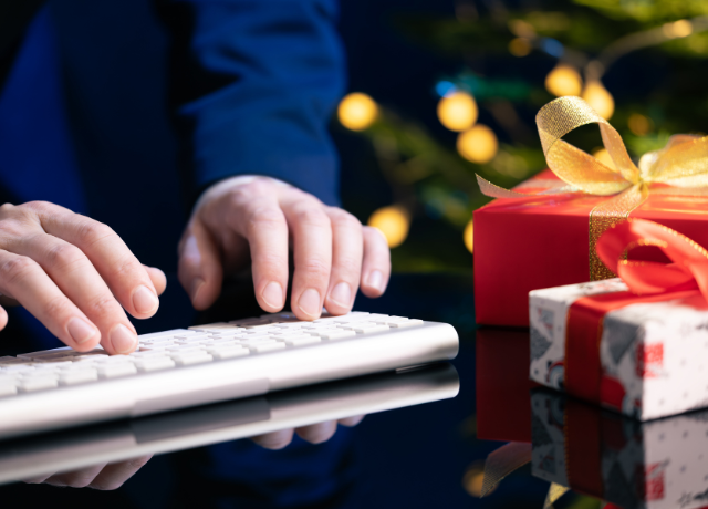 hands on keyboard next to holiday scene relating to whether to send a holiday message from your business