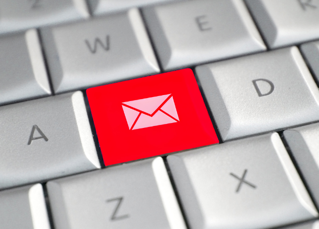 computer keyboard with email icon key in red relating to email audit before sending emails