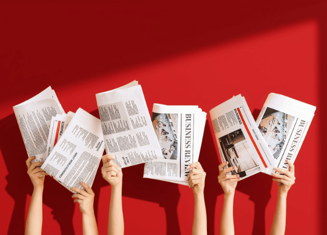 hands holding up newspapers relating to public relations helping with aeo